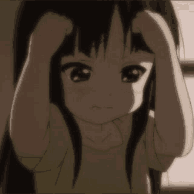 a little girl with long black hair is holding her head with both hands .