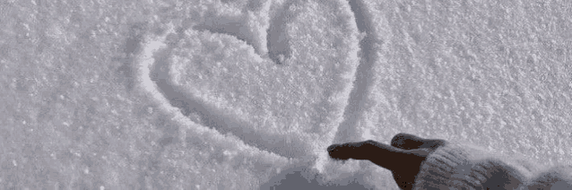 a person is writing a heart in the snow .