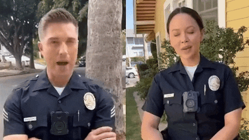 a man and a woman in police uniforms are standing next to each other on the street .
