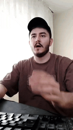 a man with a beard and mustache wearing a brown shirt that says ucsd on it