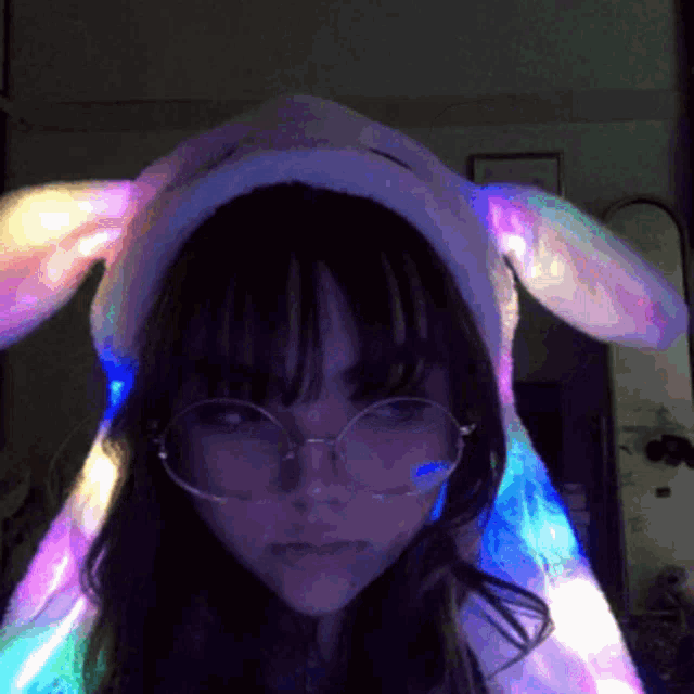 a girl wearing glasses and a bunny hat with lights on it