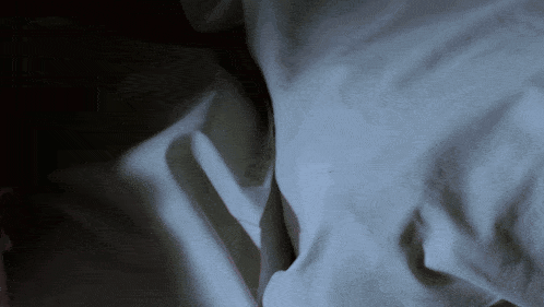 a close up of a piece of white cloth with a dark background