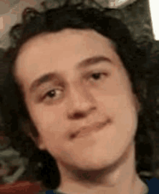 a close up of a young man 's face with a slight smile on his face .