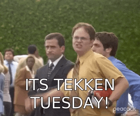 a man in a suit and tie is standing in a crowd of people and says `` its tekken tuesday ! ''