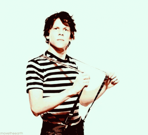 a man wearing a black and white striped shirt and suspenders holds his chest