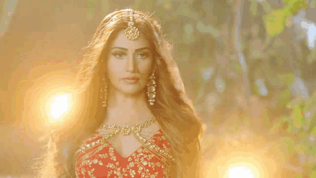 a woman in a red and gold dress with long hair