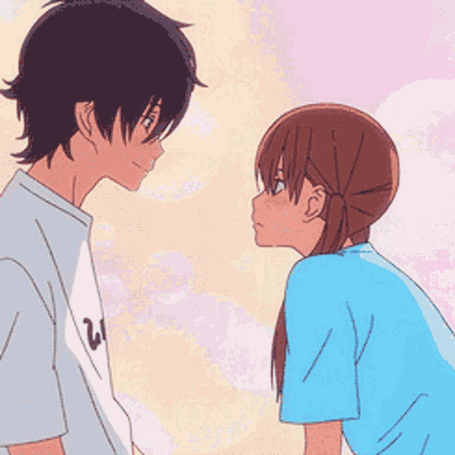 a boy and a girl are looking at each other and the girl is wearing a blue shirt with the letter w on it