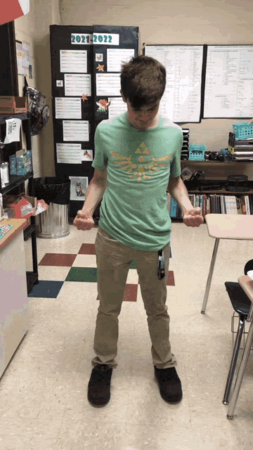 a boy wearing a zelda shirt stands in front of a bulletin board that says " 2021-2022 "