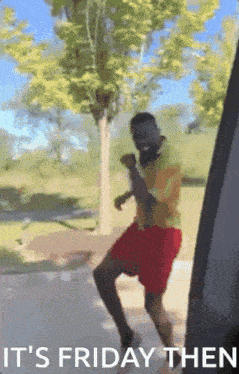 a man in a yellow shirt and red shorts is dancing with the words it 's friday then