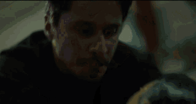 a man and a woman are kissing in a dark room in a movie .