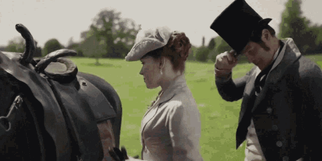 a man in a top hat holds a woman 's hand