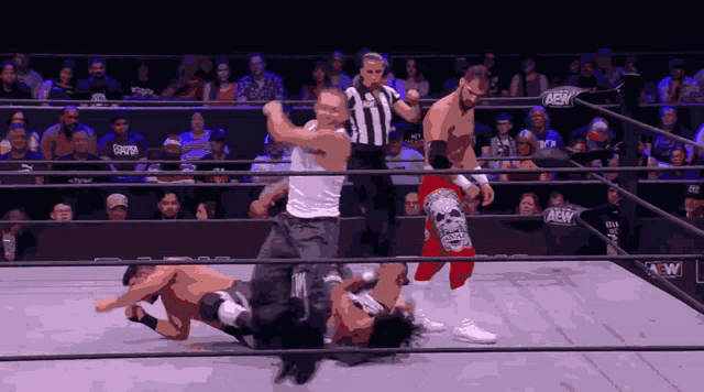 a wrestler with a skull on his shorts is being pinned by another wrestler