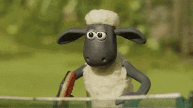 a cartoon sheep with big eyes is standing on a fence holding a racket .