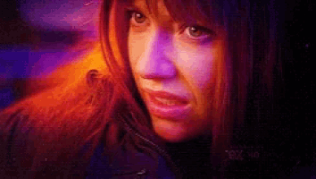 a close up of a woman 's face with a purple background