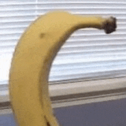 a banana is sitting on a counter next to a window with blinds .