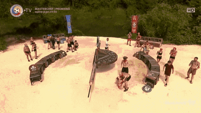 a group of people standing on a sandy beach with a sign that says masterchef premiera