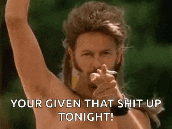 a shirtless man with a mullet is pointing at the camera while smoking a cigarette .