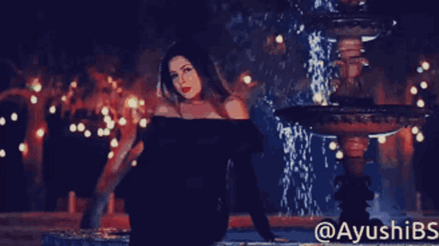 a woman in a green dress is dancing in front of a crowd with the hashtag ayushibs on the bottom