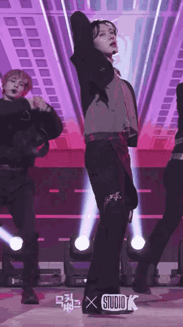 a man is dancing on a stage in front of a studio k sign