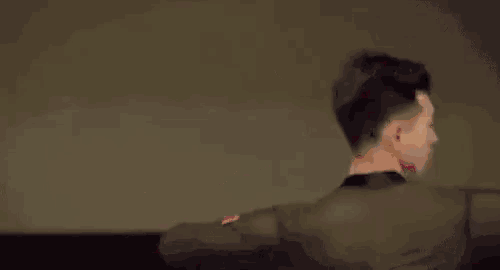 a man is dancing without a shirt on in a black jacket .
