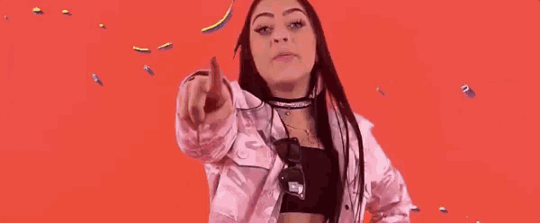 a woman in a pink jacket is pointing at the camera with a red background that says e boa