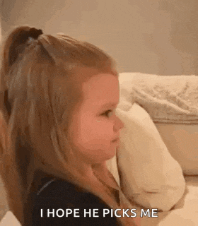 a little girl is sitting on a couch and making a face .