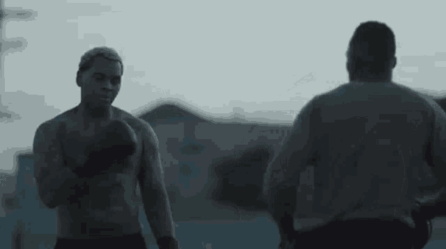 a couple of men are standing next to each other in the dark .