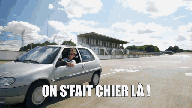 a woman is driving a car with the words on s fait chier la