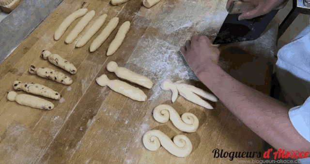 a person is cutting dough on a wooden cutting board with the words blogueurs d' alsace on the bottom right
