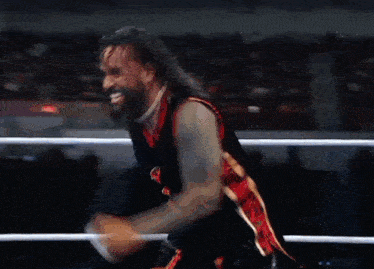 a wrestler in a black and red outfit with the number 1 on it
