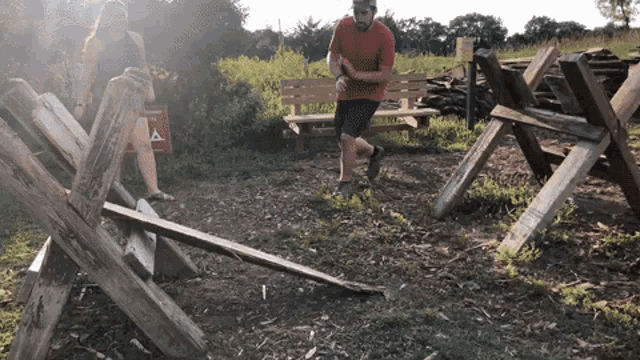 a man and a woman are walking through a wooden fence with a sign that says no camping