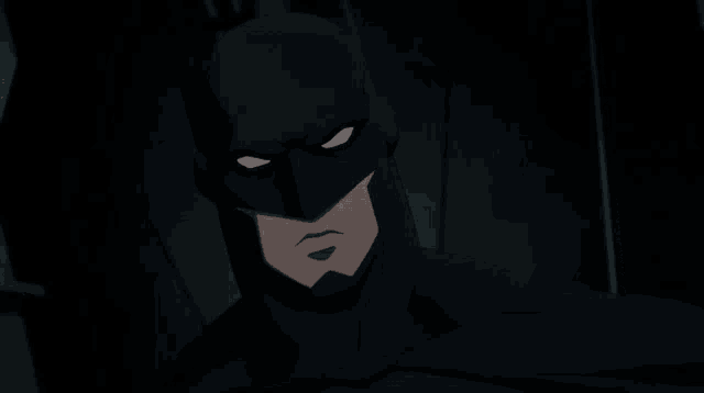 a close up of batman 's face with his eyes glowing in the dark