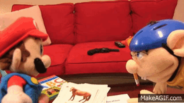 two stuffed mario toys are standing next to each other in a living room