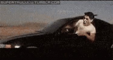 a shirtless man is driving a car with the website supertrullulu.tumblr.com visible