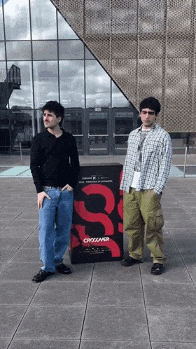 two men standing in front of a sign that says crossover