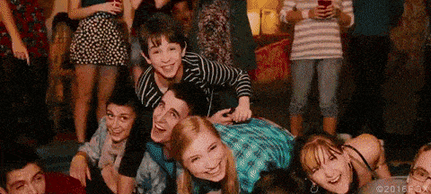 a group of young people are laying on the floor at a party and smiling .