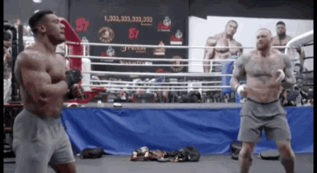 two men in a boxing ring with a sign behind them that says 1,000,000,333,333,333