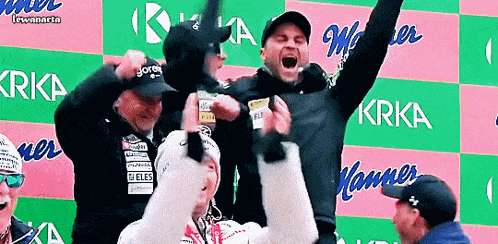 a group of men are celebrating with their arms in the air