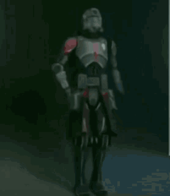a blurred image of a soldier with a red stripe on his shoulder