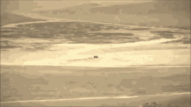 a large explosion is visible in the distance in a sepia tone