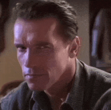 a close up of arnold schwarzenegger 's face in a dark room