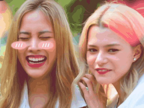 two girls with pink hair are laughing and one has a pink sticker on her cheek that says 111
