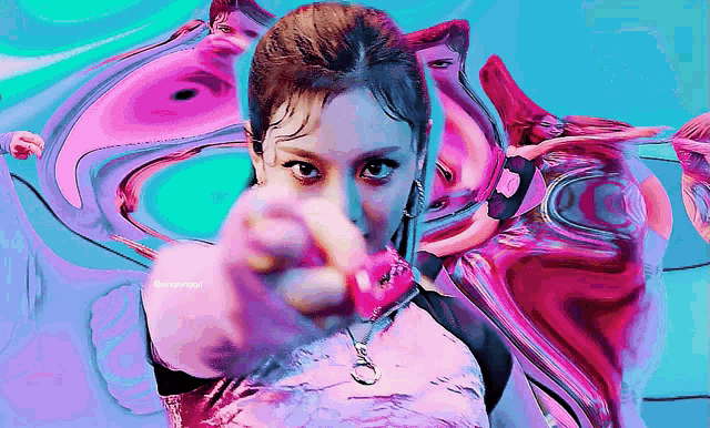 a woman is pointing her finger at the camera in a colorful background