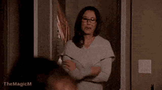 a woman wearing glasses is sitting at a table in a living room .