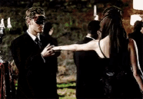 a man wearing a mask is standing next to a woman in a black dress