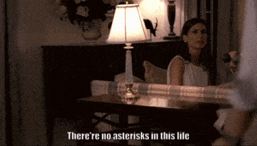 a woman sitting at a table with the words " there 're no asterisks in this life "