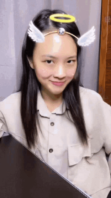 a girl wearing a halo and wings on her head