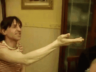 a man with very long arms is holding something in his hands .