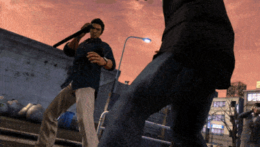a man in a blue shirt is holding a bat while standing next to another man in a suit