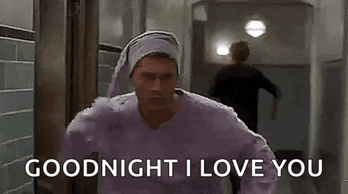 a man in a purple sweater is running down a hallway with the words `` goodnight i love you '' .